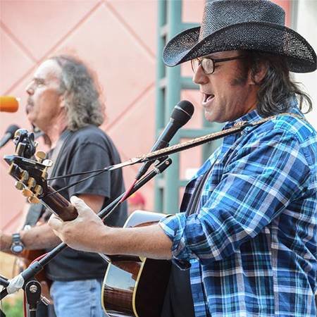 two men singing and playing guitar